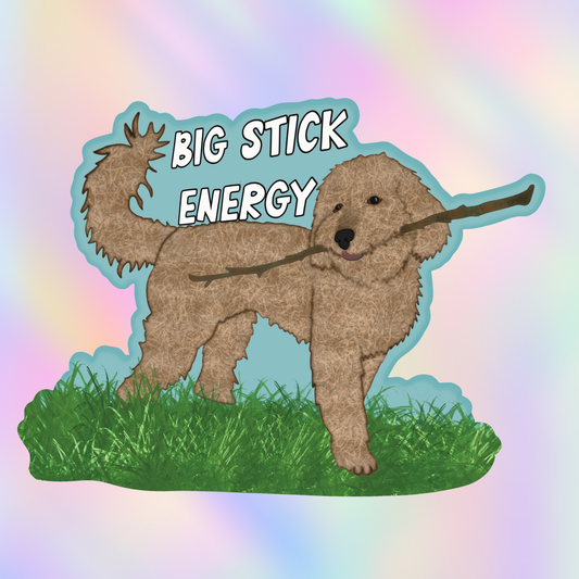 Close-up vinyl sticker of a fluffy doodle-style dog holding a large stick with the phrase “Big Stick Energy.”
